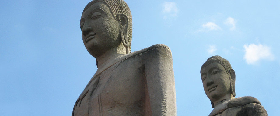 peaceful stone buddha status meditate against a calm blue sky